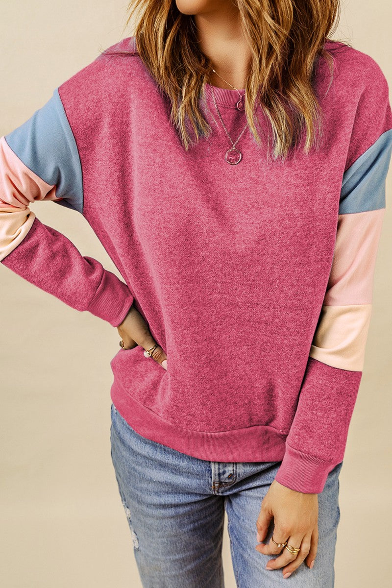 Colorblock sweatshirt with pink body and blue, pink, and cream sleeves.