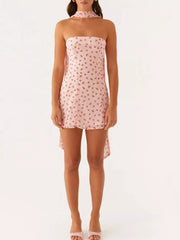 Strapless mini dress in blush pink with cherry print and a high-low hem.