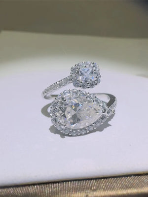Silver bypass ring with pear and cushion cut halo diamonds.