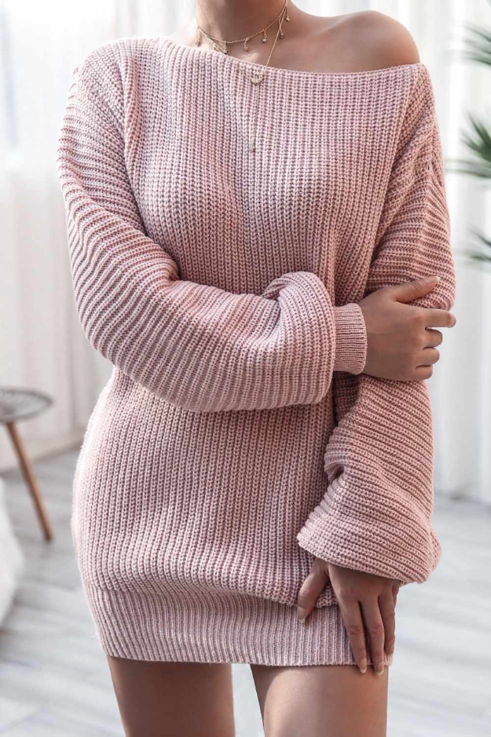 Off-the-shoulder ribbed knit mini dress in blush pink with long sleeves.