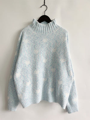 Mint blue acrylic turtleneck sweater with all-over white heart motif and textured knit.