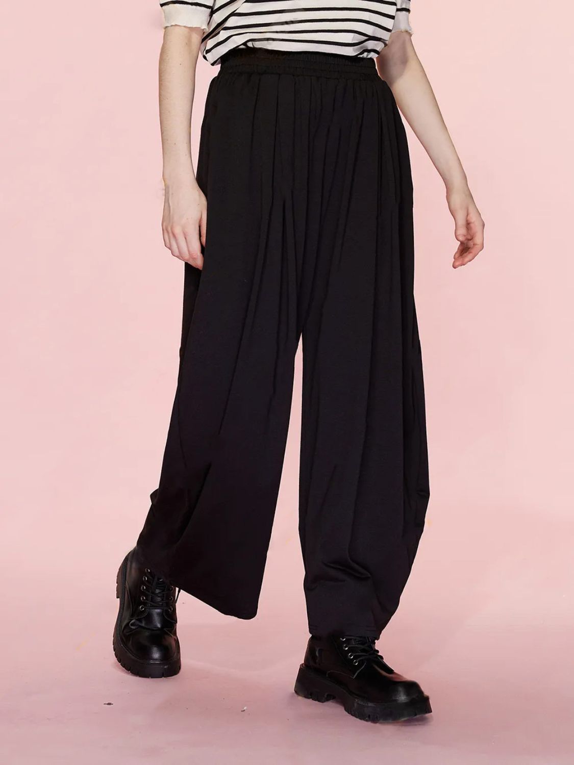 Black pleated drape palazzo trousers with wide leg and elastic waist.