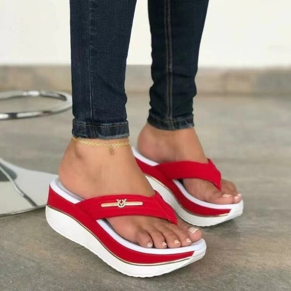 Red platform wedge sandals with elegant emblem detail and white sole.