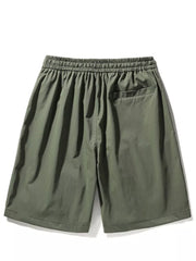 Green men's cargo shorts with elastic waistband and back pocket.