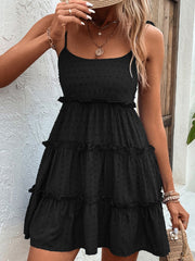 Black dotted swiss tiered mini dress with tie straps and ruffled tiers.