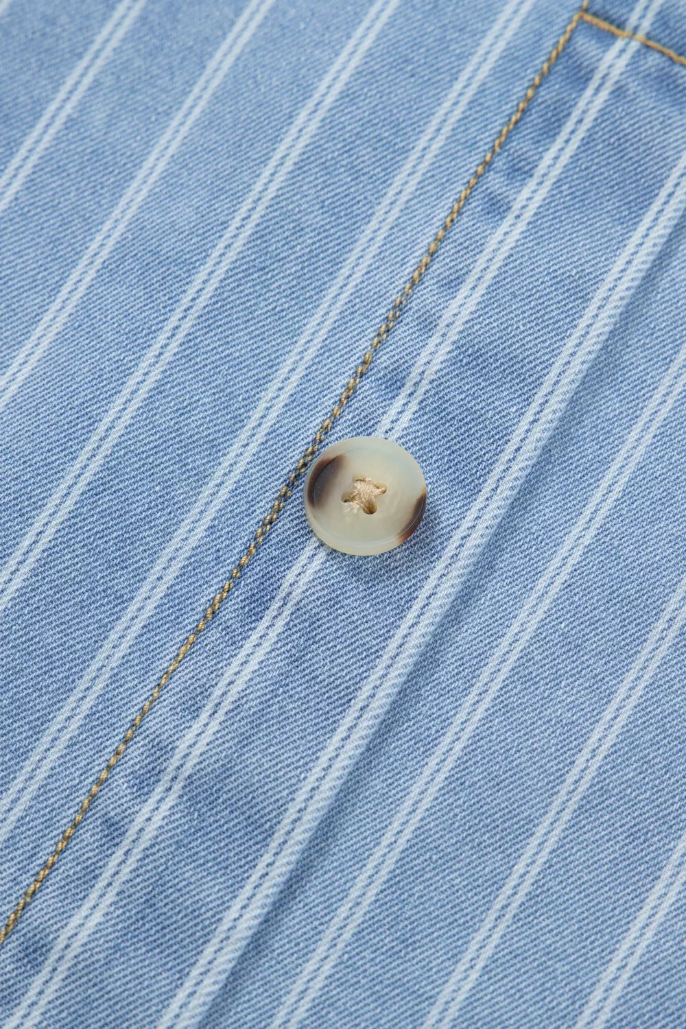 Denim mini dress with vertical white pinstripes and a light brown button detail.