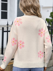 Apricot knit sweater with pink daisy intarsia pattern, crew neck, long sleeves.