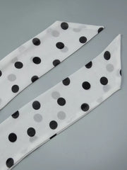 White polka dot scarf with black dots, a chic accessory.