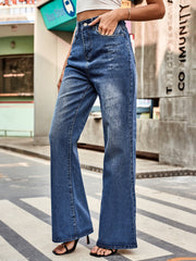 Dark blue denim flared jeans with distressed details and a buttoned fly.