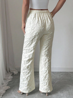 Textured cream high-waist wide-leg maternity pants with pockets and floral embroidery.