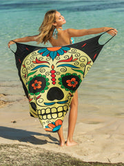 Yellow pareo wrap with a multicolor sugar skull graphic and black trim.