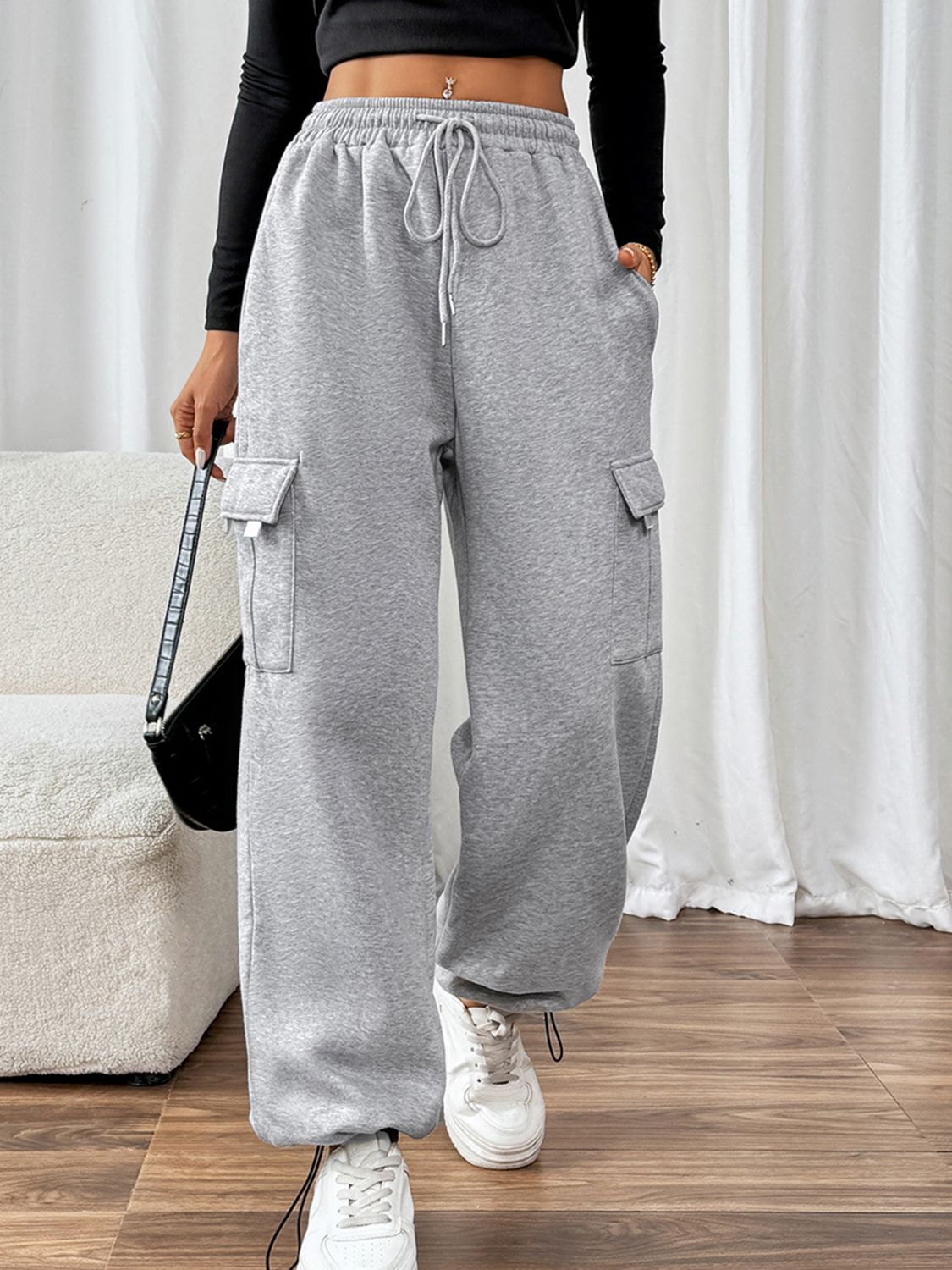 Light gray wide-leg sweatpants with cargo pockets and adjustable drawstring waist.