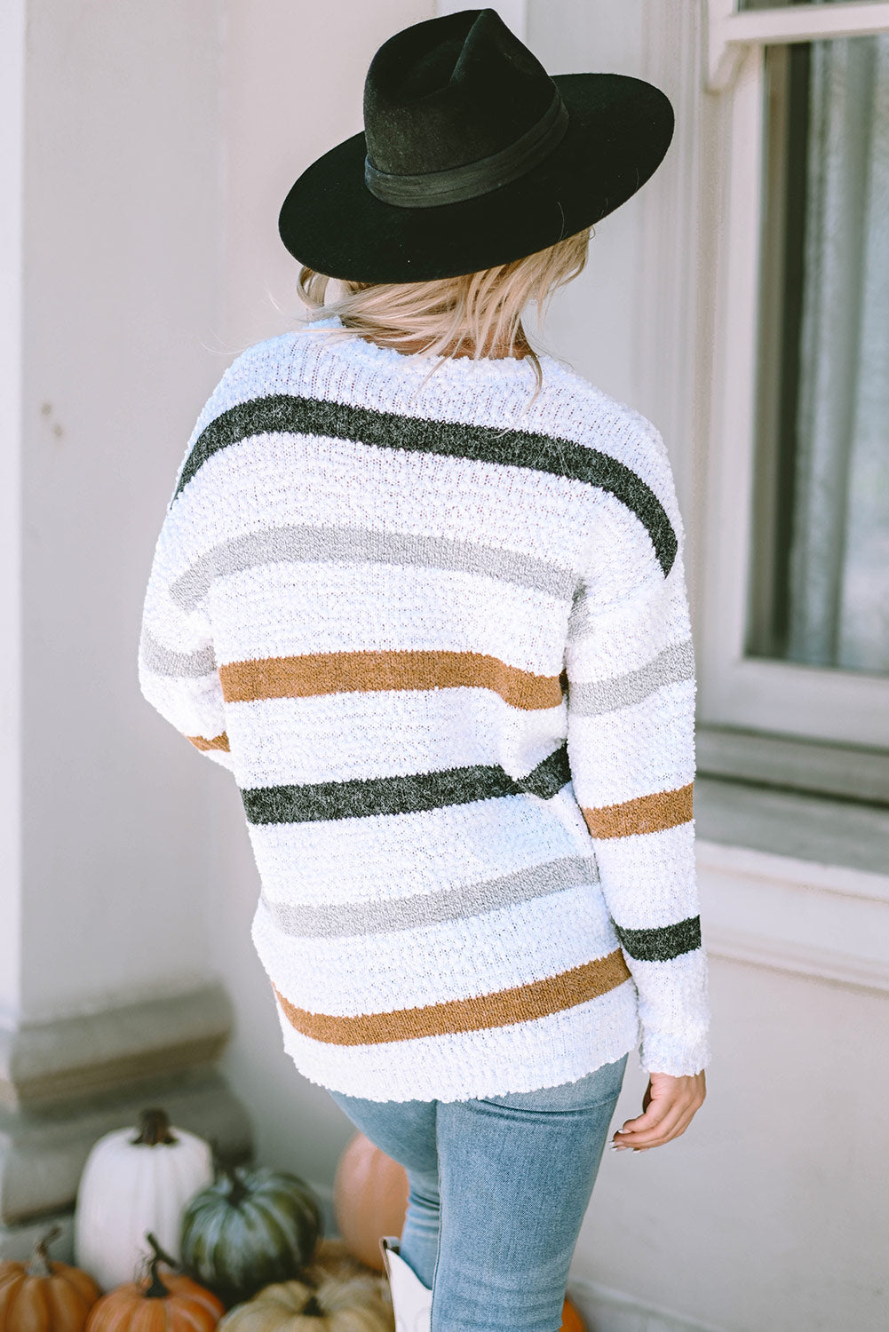 Textured stripe slouchy knit sweater in white with grey, black, and brown stripes.