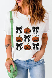 White graphic tee with a repeating pattern of jack-o'-lanterns and black bows.