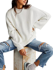 White oversized ribbed knit sweater with drop shoulders and mock neck.