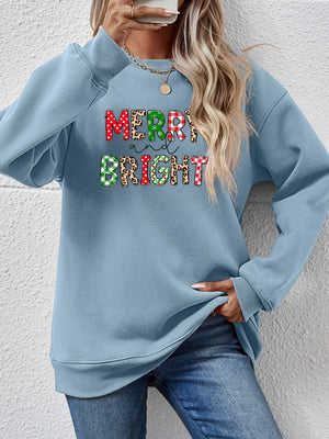 Light blue crewneck sweatshirt with "Merry and Bright" graphic in festive patterns.