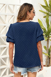 Dark blue tiered sleeve Swiss dot blouse with short sleeves and a casual fit.