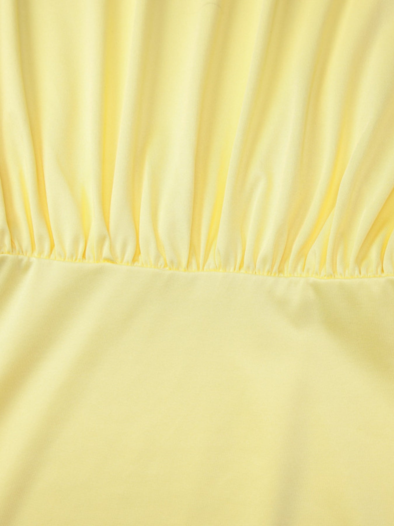 Yellow off-shoulder ruched mini dress detail showing gathered fabric and smooth skirt.