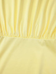 Yellow off-shoulder ruched mini dress detail showing gathered fabric and smooth skirt.