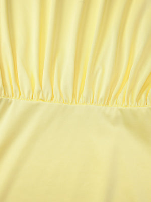 Yellow off-shoulder ruched mini dress detail showing gathered fabric and smooth skirt.
