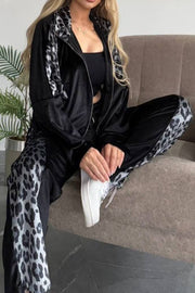 Black velvet tracksuit with leopard print panels on jacket and pants.