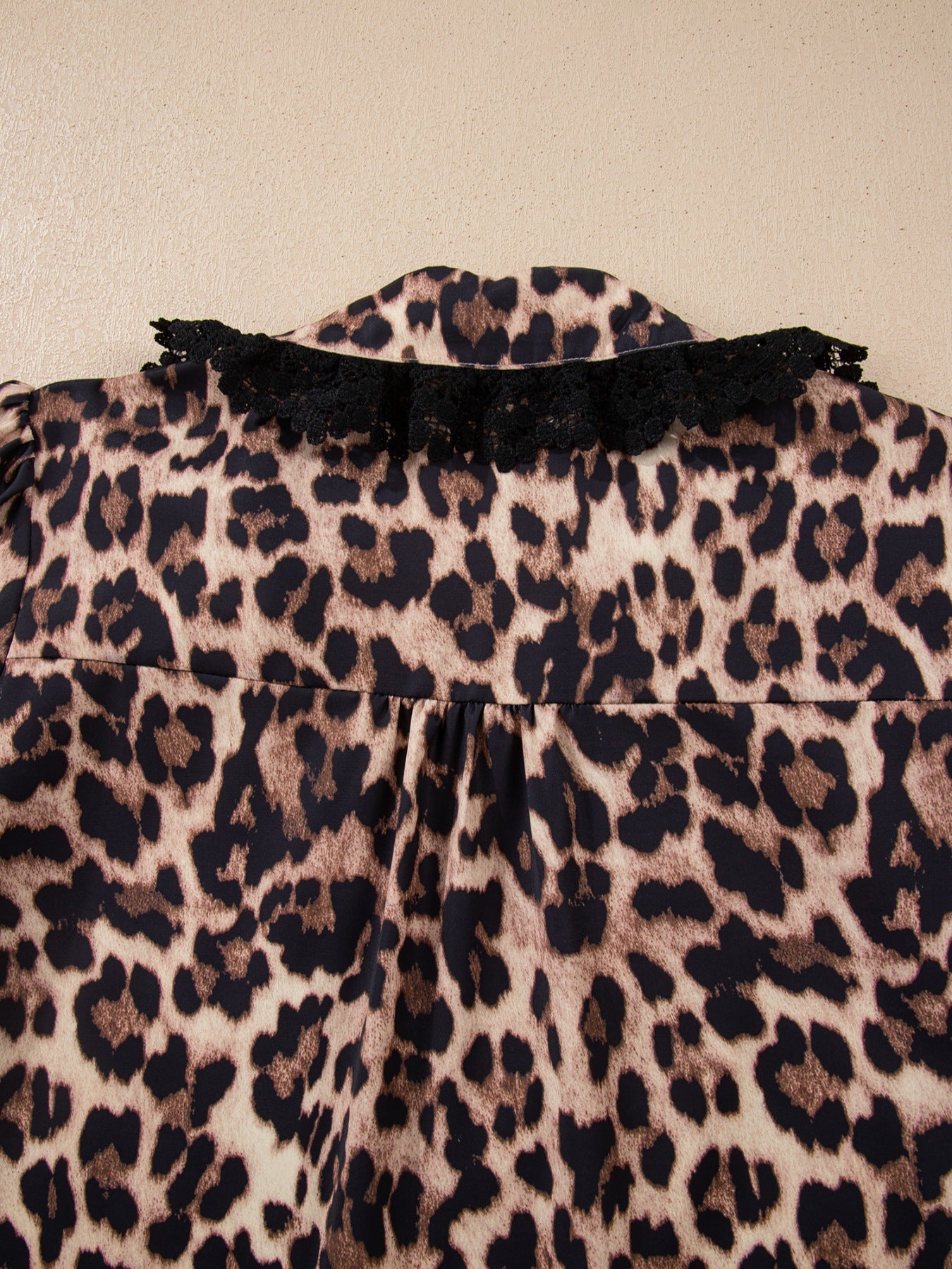 Women's leopard print shirt with black lace trim collar detail.