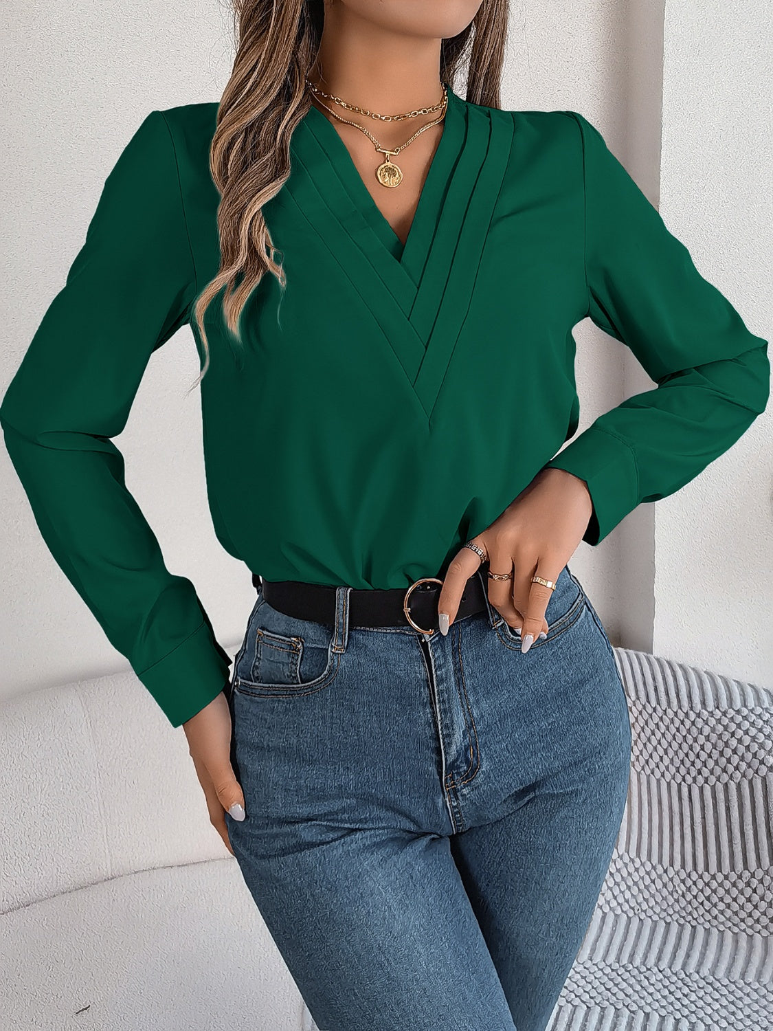 Dark Green V-neck blouse with pleated detail and long sleeves.