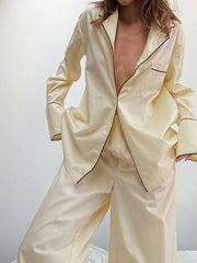 Cream button-up pajama set with black piping detail on collar, cuffs, and pocket.