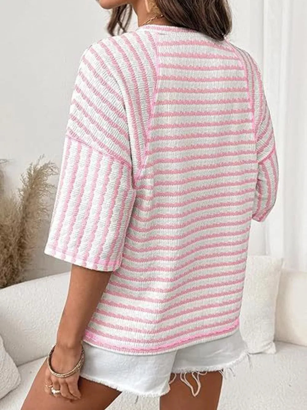 Pink and white wavy stripe knit t-shirt with relaxed fit and short sleeves.