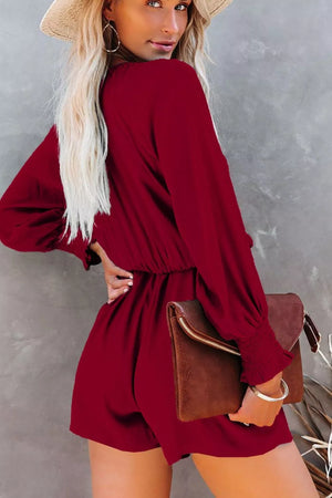 Burgundy tie knot romper with cinched waist and puff sleeves.
