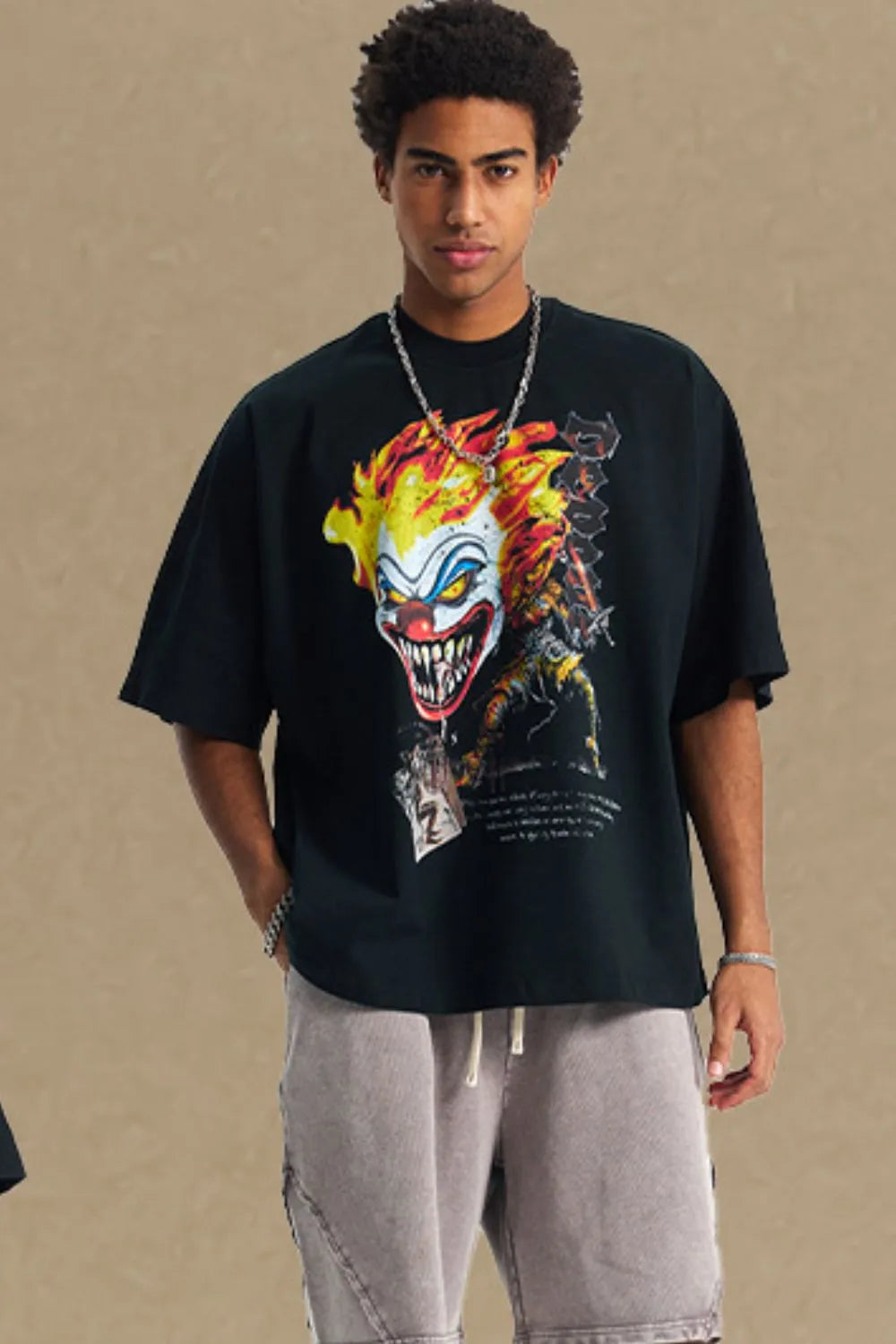 Black oversized t-shirt with a bold clown graphic print and short sleeves.