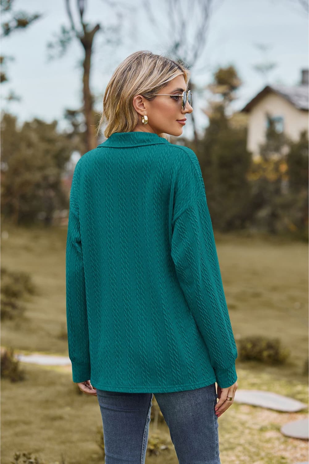 Turquoise cable knit polo top with textured pattern and long sleeves.