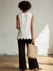 White sleeveless tank top with scalloped hem detail and keyhole back.