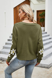 Moss green acrylic knit cardigan with white daisy print on sleeves, v-neck, and ribbed cuffs.
