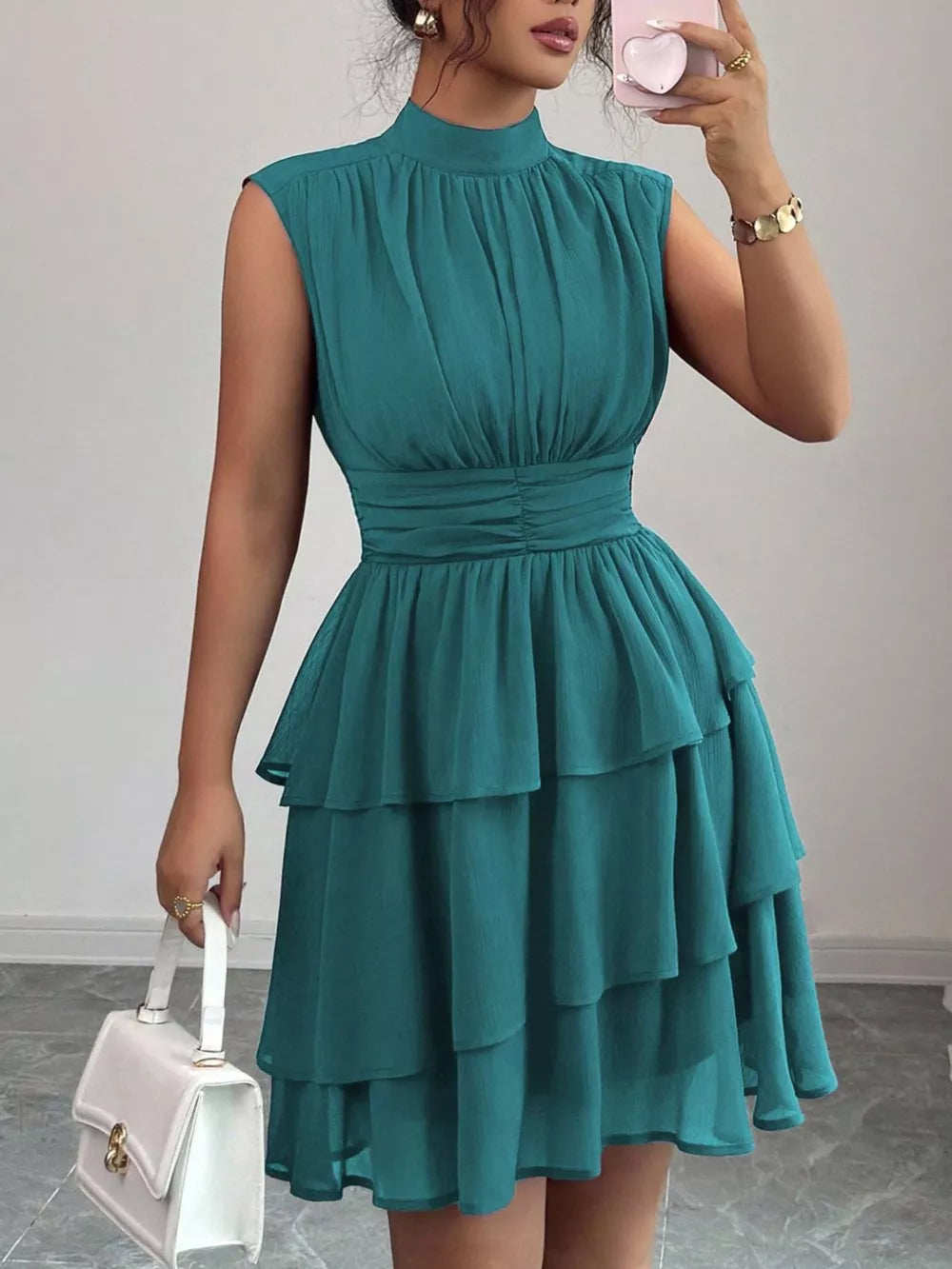 Sleeveless teal ruffled tiered dress with ruched bodice and mock neck.
