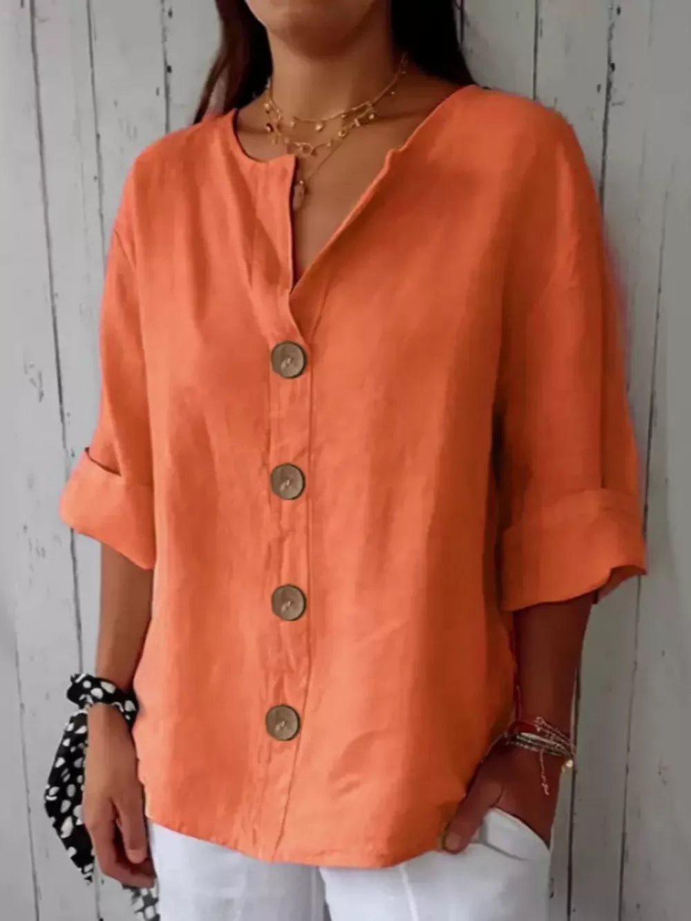 Orange button-down shirt with relaxed fit, cuffed sleeves, and wooden buttons.