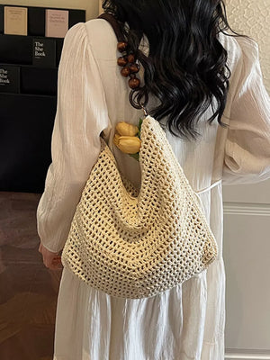 Textured knit shoulder bag in ivory with a wooden bead handle and a boho chic style.