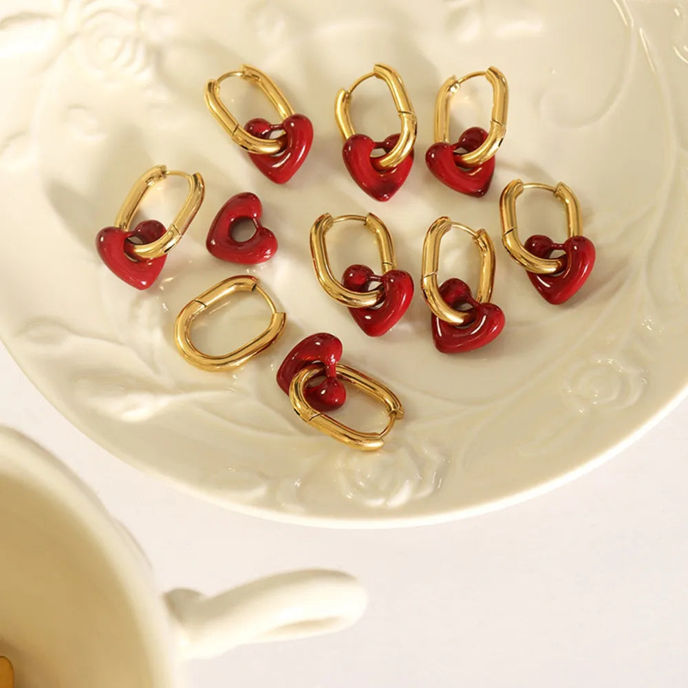 Gold hoop earrings with red enamel heart charms