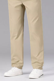 Men's khaki slim-fit stretch dress pants with white sneakers