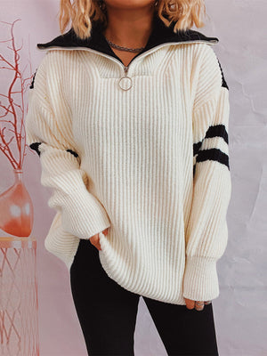 Cream acrylic sweater with black varsity stripes on sleeves and black zip collar.
