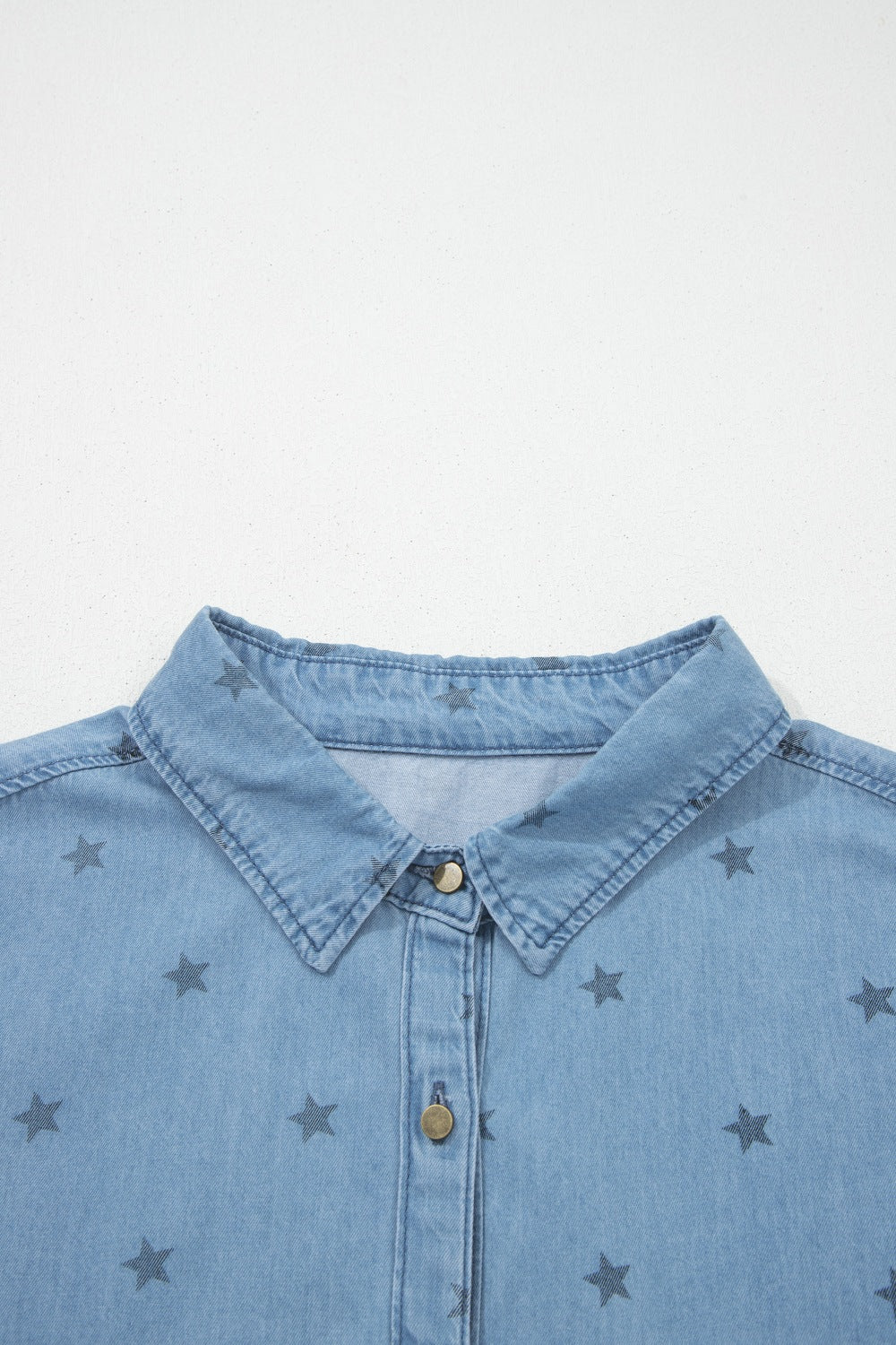 Light blue denim shirt with dark star print, button-down collar, and button front.