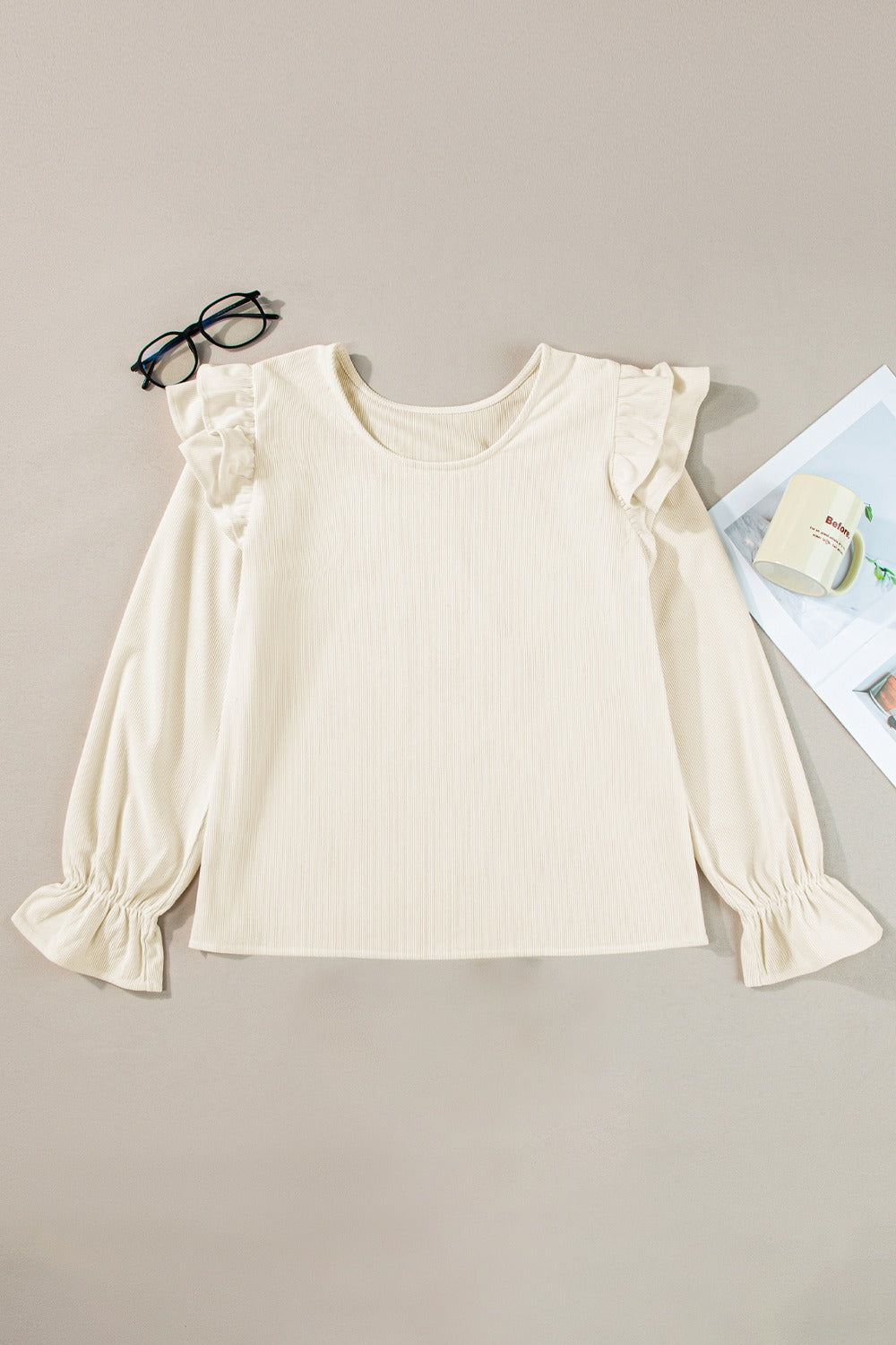 Textured ruffle sleeve blouse in eggshell with ribbed fabric and gathered cuffs.