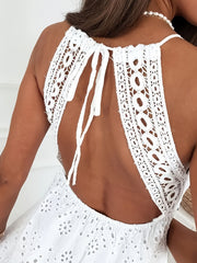 White eyelet lace mini dress with open back and tie detail.