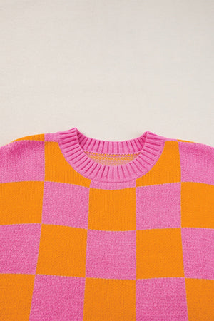 Checkerboard knit sweater in pink and orange with a crew neck and cap sleeves.