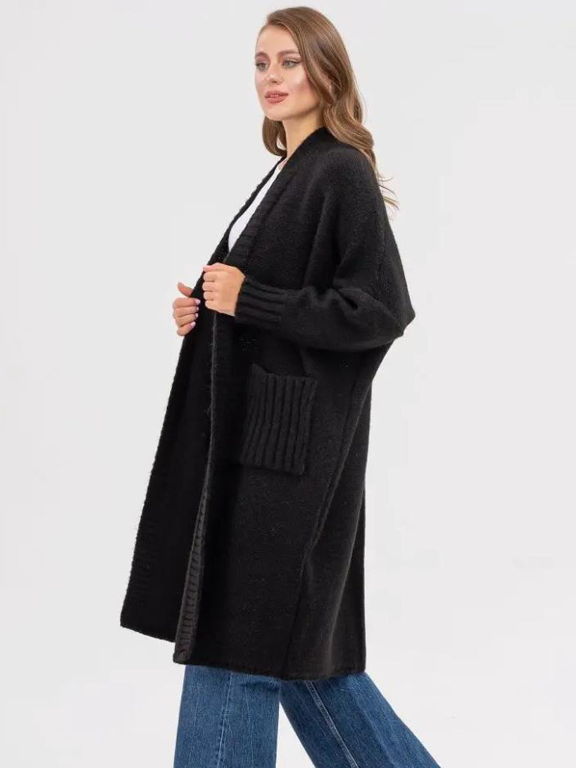 Black oversized acrylic knit cocoon cardigan with ribbed pockets and cuffs.
