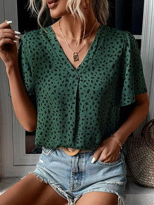 Emerald leopard print V-neck blouse with short flutter sleeves.
