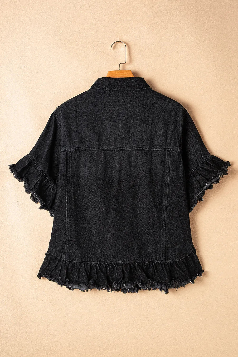 Black denim trucker jacket with short ruffled sleeves and hem.