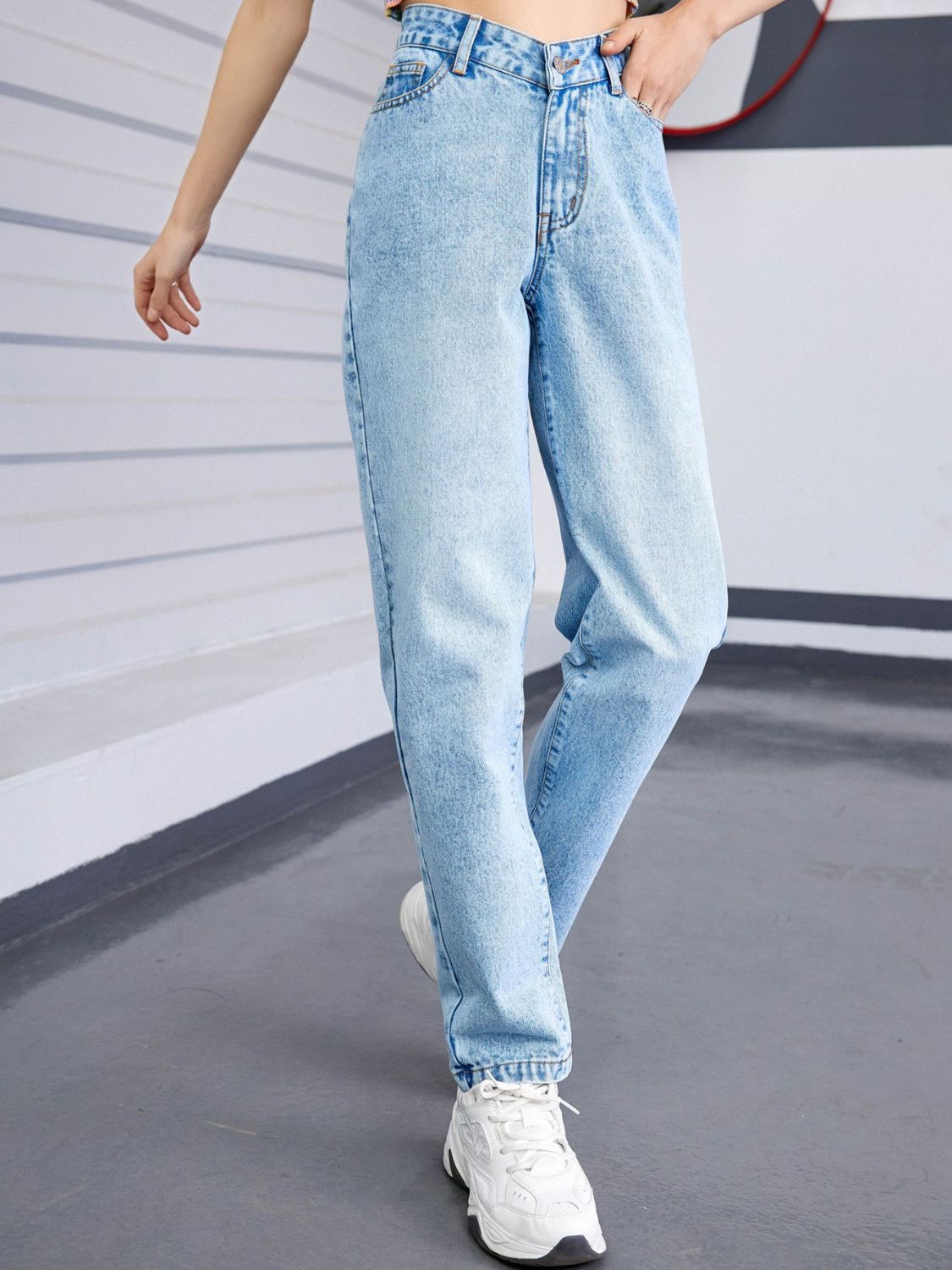 Light wash denim jeans with a V-waistline and relaxed fit.