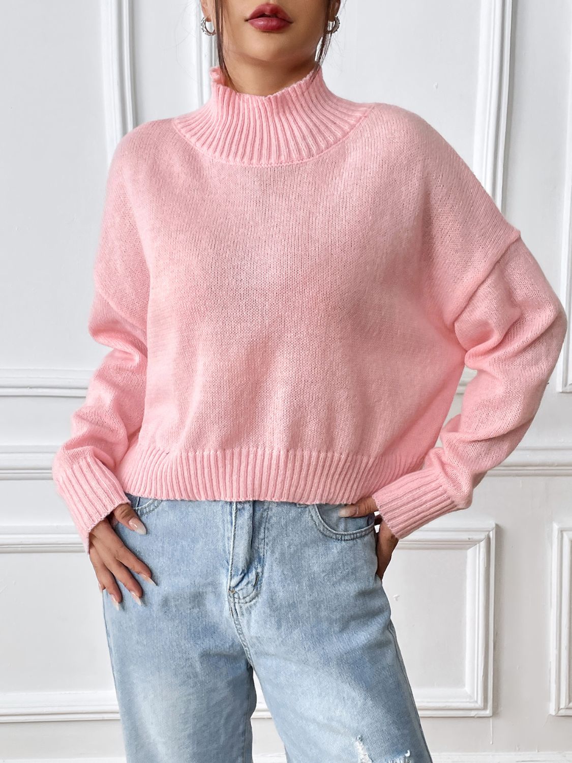Cropped ribbed turtleneck knit sweater in blush pink with a relaxed fit.