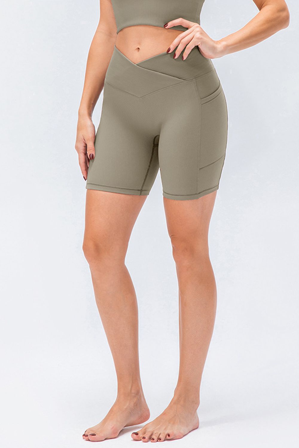 Cross-waist bike shorts in Matcha Green with side pockets.